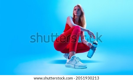 Fitness neon light sporty concept portrait of fitness female model in abstract style background. Health care concept. Healthy lifestyle. Fitness woman taking break after at gym Royalty-Free Stock Photo #2051930213