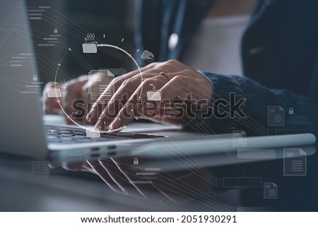 Document Management System (DMS) being setup by IT consultant working on laptop computer in office. Software for archiving, searching and managing corporate files and information Royalty-Free Stock Photo #2051930291