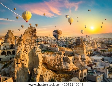 Hot air balloons at sunset in Goreme village, Cappadocia, Turkey Royalty-Free Stock Photo #2051940245