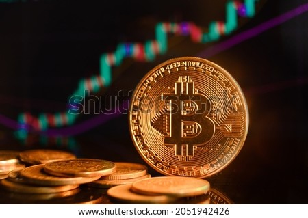 Bitcoin and cryptocurrency investing concept. Bitcoin cryptocurrency gold coin. Trading on the cryptocurrency exchange. Trends in bitcoin exchange rates. Rise and fall charts of bitcoin. Royalty-Free Stock Photo #2051942426