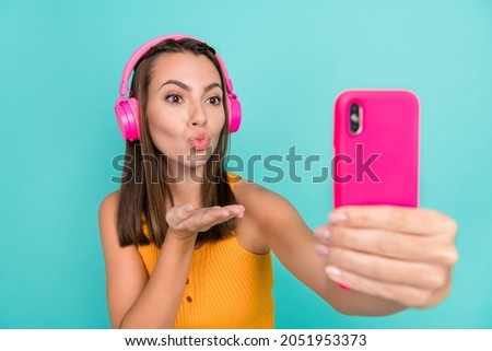 Photo of happy brunette trendy stylish woman send air kiss wear headset selfie phone isolated on teal color background