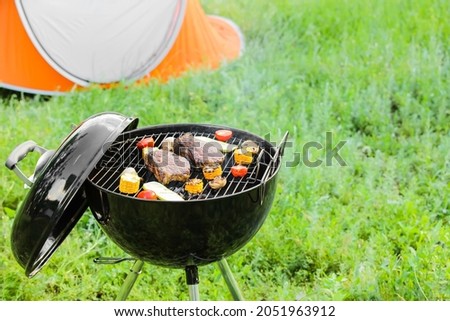 Barbecue grill with tasty steaks and vegetables outdoors