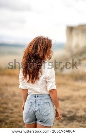  Rear view of a young woman with gorgeous hair, wild west concept