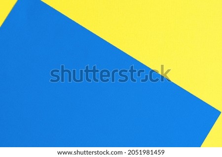 Multi colored abstract paper of pastel blue and yellow colors palette, with geometric shape, flat lay.