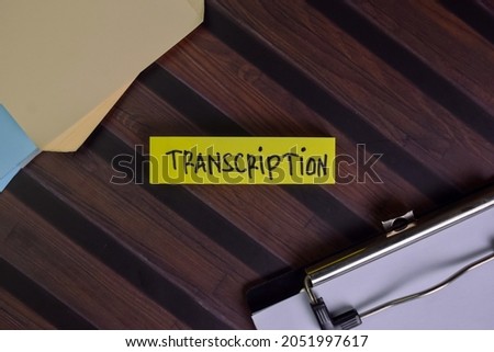 Transcription write on sticky notes isolated on Wooden Table.