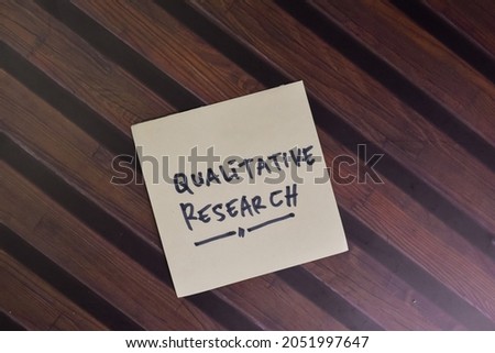 Qualitive Research write on sticky notes isolated on Wooden Table. Royalty-Free Stock Photo #2051997647