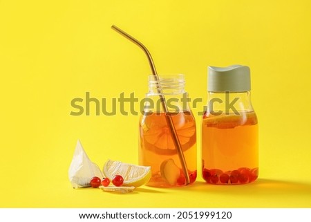 Bottles of fresh ice tea on color background