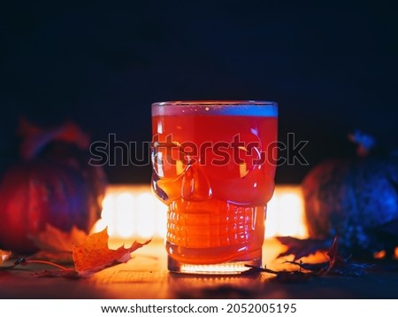 Happy Halloween. A glass of beer in the shape of a skull, dark background.