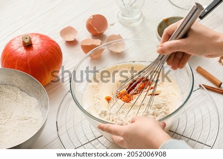 Woman preparing pumpkin pie on table