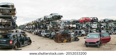 Old rusty corroded and crushed cars in car scrapyard. Car recycling.  Ecological concept by dump of wrecked cars.  Royalty-Free Stock Photo #2052033200