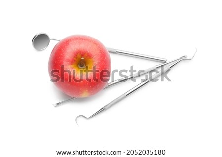 Dentist's tools with apple on white background