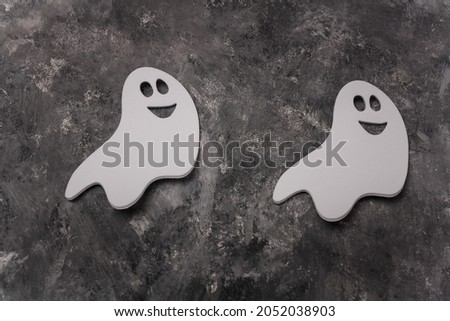 Two Halloween white ghosts shape stickers on grey background. Halloween concept, close up