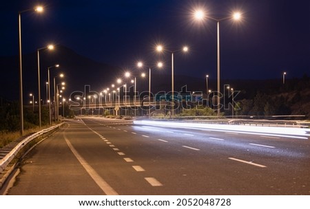Asphalt highway and electric poles at night