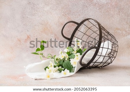 Overturned basket with beautiful jasmine flowers on grunge background
