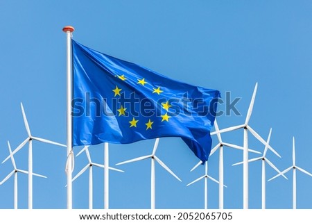 Official flag of the European Union in front of a large windpark with wind turbines Royalty-Free Stock Photo #2052065705