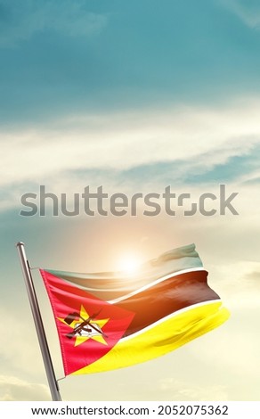 Mozambique national flag waving in beautiful clouds.