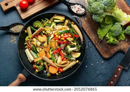 Frying pan with different vegetables on dark background Royalty-Free Stock Photo #2052076865
