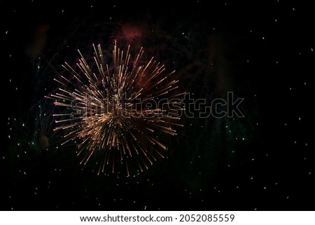 Salute in the sky. Explosion of fireworks in the night sky. Firecrackers flapping sparks in a dark space. Festive fireworks. Background with sparks from burning gunpowder. Royalty-Free Stock Photo #2052085559