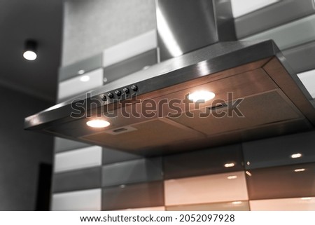  kitchen metal hood with illumination close-up. extractor hood in the restaurant. electrical equipment for the kitchen                            Royalty-Free Stock Photo #2052097928