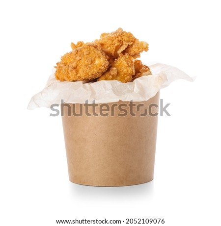 Paper bucket with tasty fried popcorn chicken on white background Royalty-Free Stock Photo #2052109076