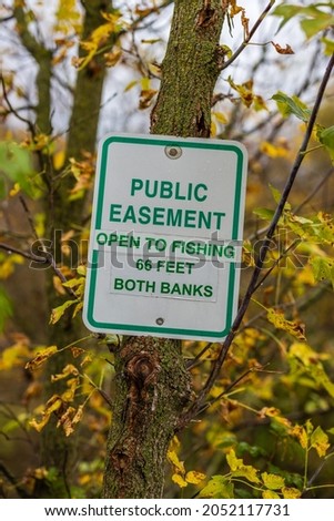 Easement sign to notify public fishing is allowed. Selective focus, background and foreground blur.
