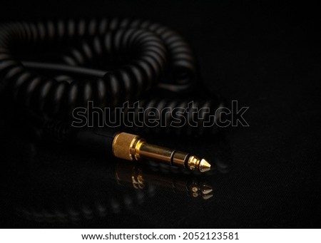Gold-plated TRS connector for the analog audio signal are placed against a black background. Professional jack connector for sound equipment. Audiophile technologies concept.