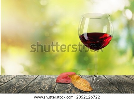 Wine glass with red wine and autumn leaves. Creative wine degustation