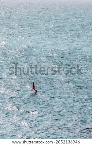 practicing windsurfing in the Atlantic, on the beach of Etretat, Normandy, France, during sunset