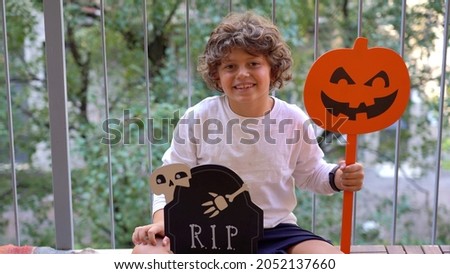 7 year old caucasian child awaits the arrival of Halloween day at home on the balcony during covid-19 Coronavirus lockdown pandemic