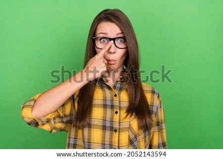 Photo of stunned young girl finger touch fixing glasses look camera facial reaction isolated on green color background