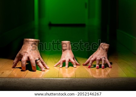 Family of Chopped Off Severed Hands Walking in Hallway with Green Light and Wedding Rings Spooky Scary for Halloween Royalty-Free Stock Photo #2052146267
