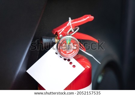 Chemical fire extinguisher with pressure gauge and monthly inspection verify tag. Industrail and emergency equipment object photo. Close-up and selective focus at gauge part.