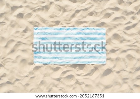 Striped beach towel on sand, aerial view Royalty-Free Stock Photo #2052167351