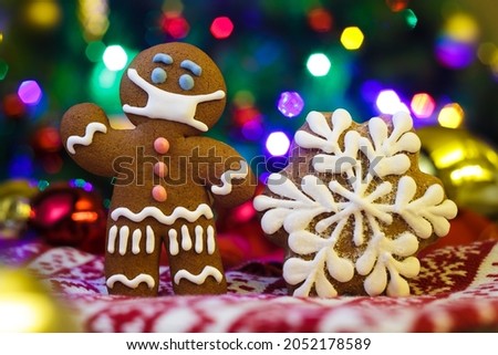 Christmas background with gingerbread man with protective medical mask. Happy New Year festive background
