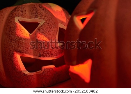Two glowing carved pumpkins in a dark background - halloween concept