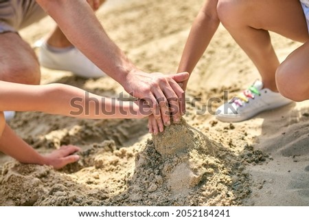 Close up picture of hands making castles from sand