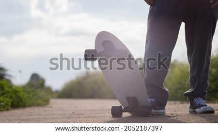 A young man is happily skating down a country road alone to practice his skating skills and have a fun break. Skate surfing skills practice ideas in your spare time to prepare for competitions.