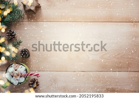 Christmas background with marshmallow hot chocolote, wooden snowflakes and Christmas tree branches on wooden background with copy space, Christmas and New Year greeting card