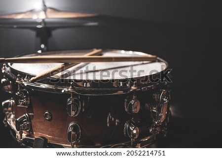 Snare drum, percussion instrument on a dark background with stage lighting. Royalty-Free Stock Photo #2052214751