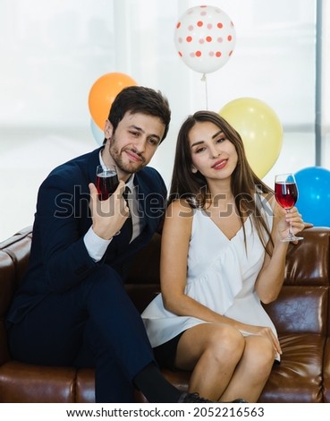 Drunken Caucasian male in business suit and female lover couple in casual dress sitting drinking alcohol at food snack drink and beverage counter table bar in Christmas eve festival celebration party.