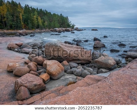 Northern landscape in autumn, Kivipark nature reserve in the Vyborg district of the Leningrad region. Gulf of Finland of the Baltic Sea with huge boulders near the forest. Royalty-Free Stock Photo #2052235787
