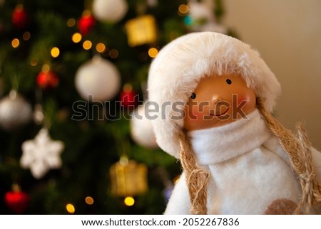 doll, girl in a fur coat and hat, snow maiden, Christmas decor, toys, bows, glass balls, bokeh, background, toys, merry christmas, happy new year. Lights, sparkles and highlights, snow, Christmas tree