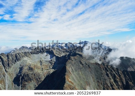 Panoramic photo of bare mountains with beautiful blue sky with clounds on a sunny day. High Tatras, Slovakia