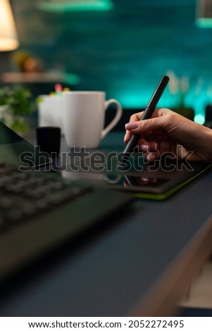 Close up of woman using photo editing technique on project while working with stylus and digital tablet for retouching production. Person doing design on computer interface for template