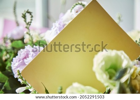 Mock-up of yellow post card close up with delicate big flowers bouquet of eustoma. Copy space. Flowers delivery and present concept. High quality photo