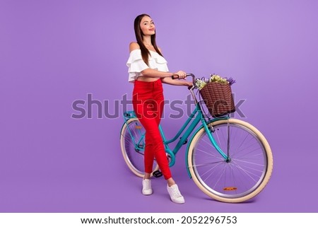 Photo of cheerful dreamy inspired lady drive bike deliver flowers wear white blouse isolated violet color background