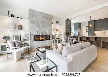 contemporary living room with open concept view through to dining room kitchen and a marble fireplace with gas fire Royalty-Free Stock Photo #2052298703