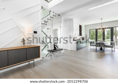 Entry hall and foyer with glass walls stairs console table bench and wooden door Royalty-Free Stock Photo #2052298706