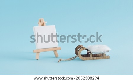 A creative Christmas arrangement made of sleighs and easels on blue background. Minimal winter concept. New Year inspiration.