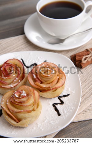 Tasty  puff pastry with rose shaped apples on plate on table close-up